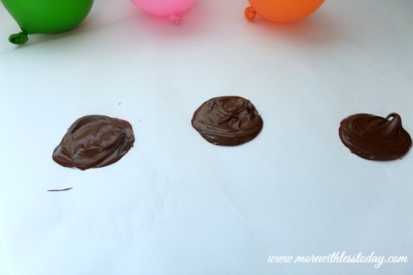 putting spoonfuls of melted chocolateon parchment paper to make edible chocolate dessert bowls