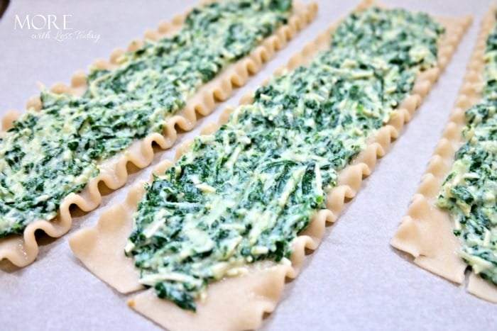 Spreading the spinach on a lasagna