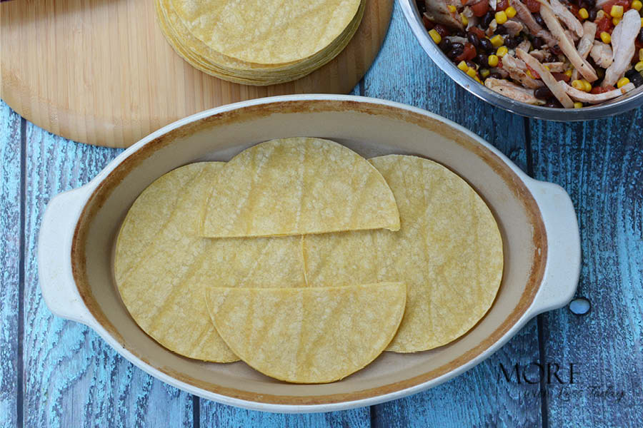 layering corn tortillas to make Four Cheese Bake recipe