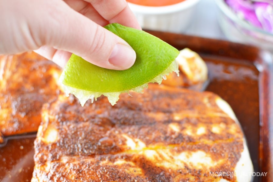 squeezing a lime on cod fish for fish tacos