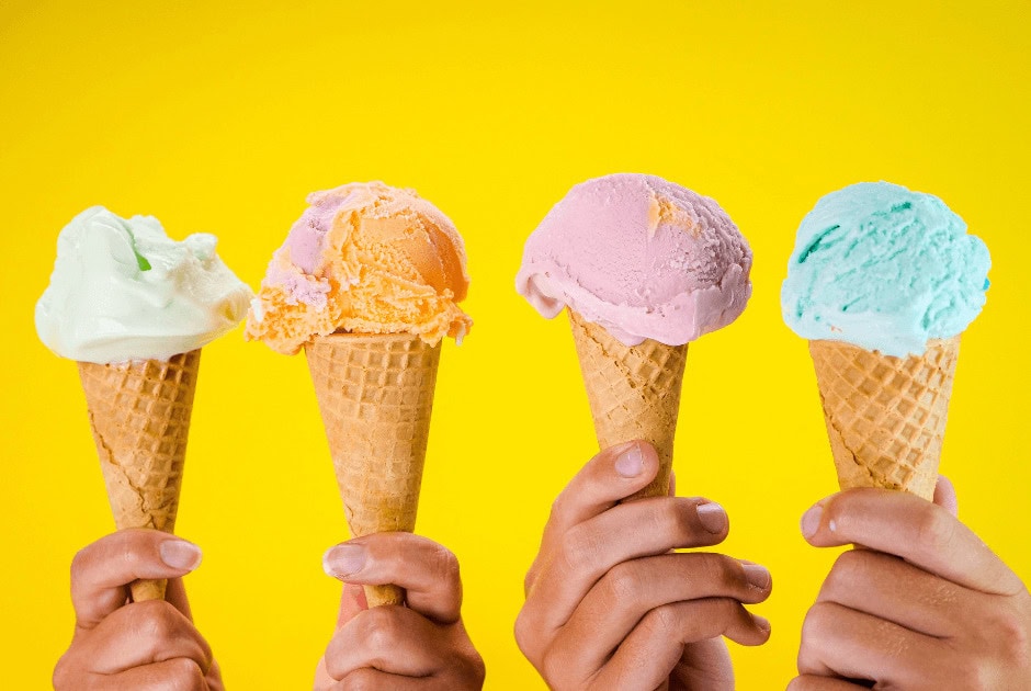 A closeup of four ice cream cones