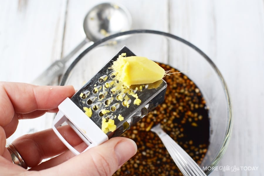 using a small grater to add fresh ginger to a recipe