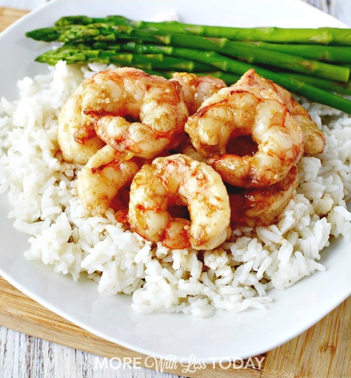 shrimp on a bed of white rice with asparagus spears