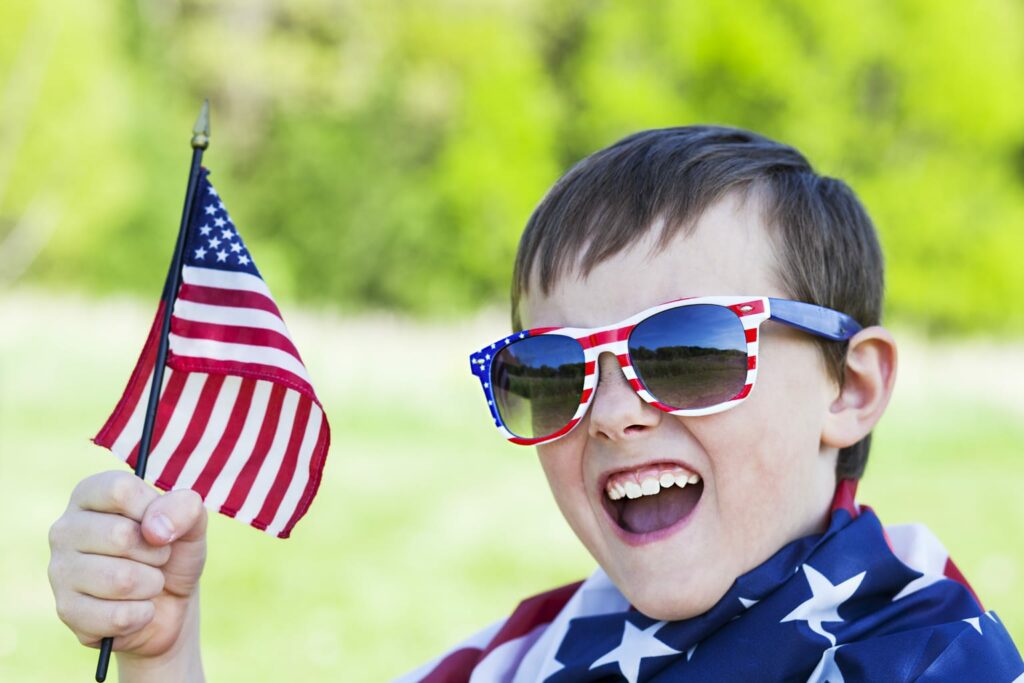 boy with American flag and red white and blue sunglasses