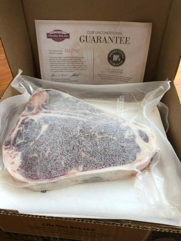 Omaha Steaks guarantee photo of a steak flash frozen and vacuum sealed in a box for delivery