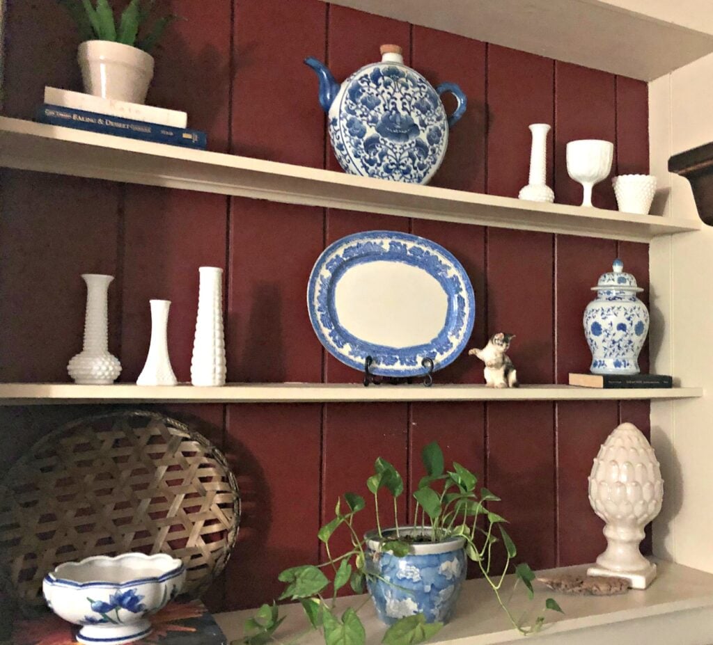 shelves with the backing painted red with blue and white decor