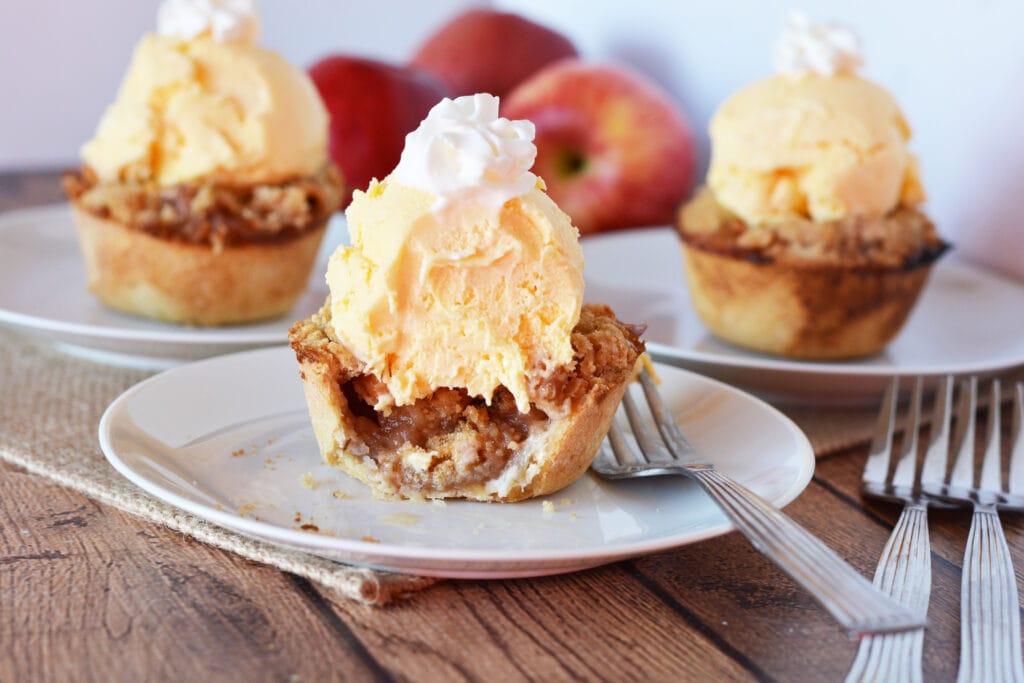 mini apple pies with ice cream and whipped cream topping