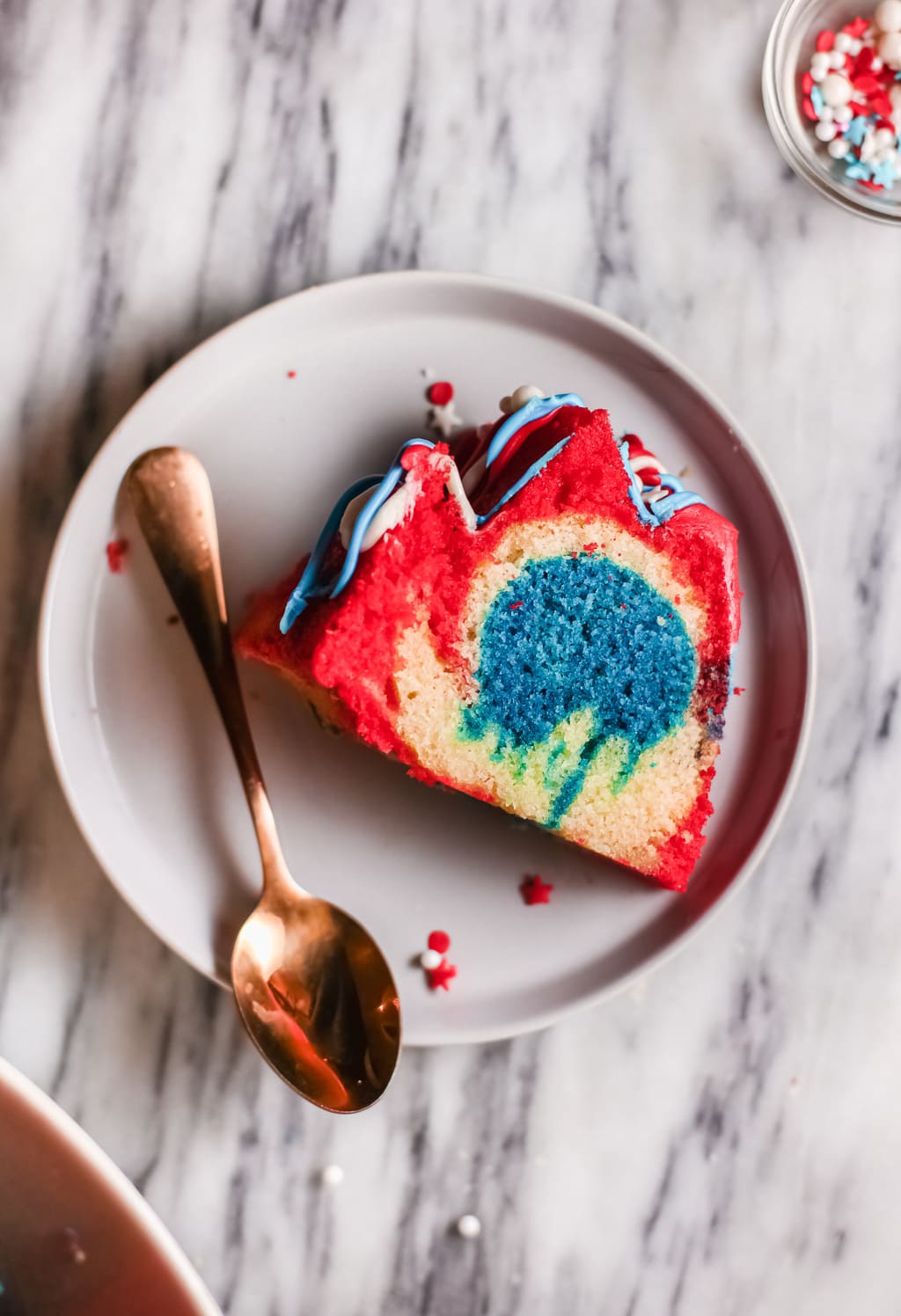 a slice of Firecracker cake looking at the color inside with a spoon