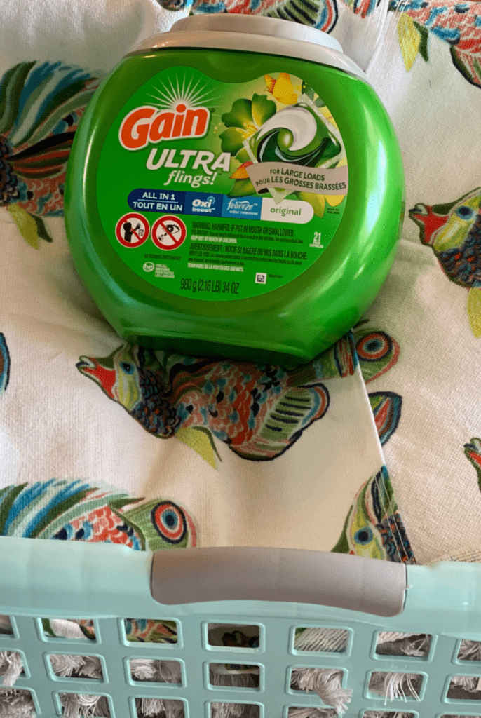 Gain Ultra Flings with Oxi Boost and Febreze for Large Loads in a laundry basket with colorful fish towels