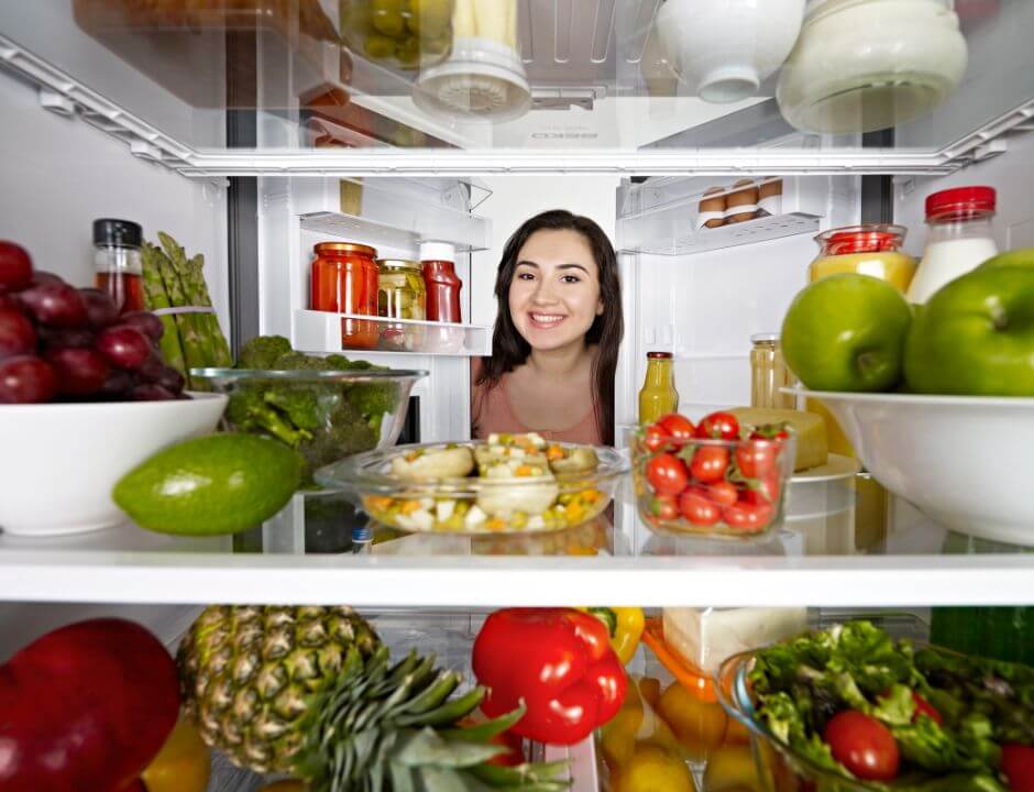 A woman looking inside the fridge