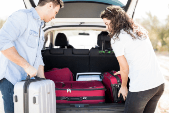 woman and man packing suitcases in the car