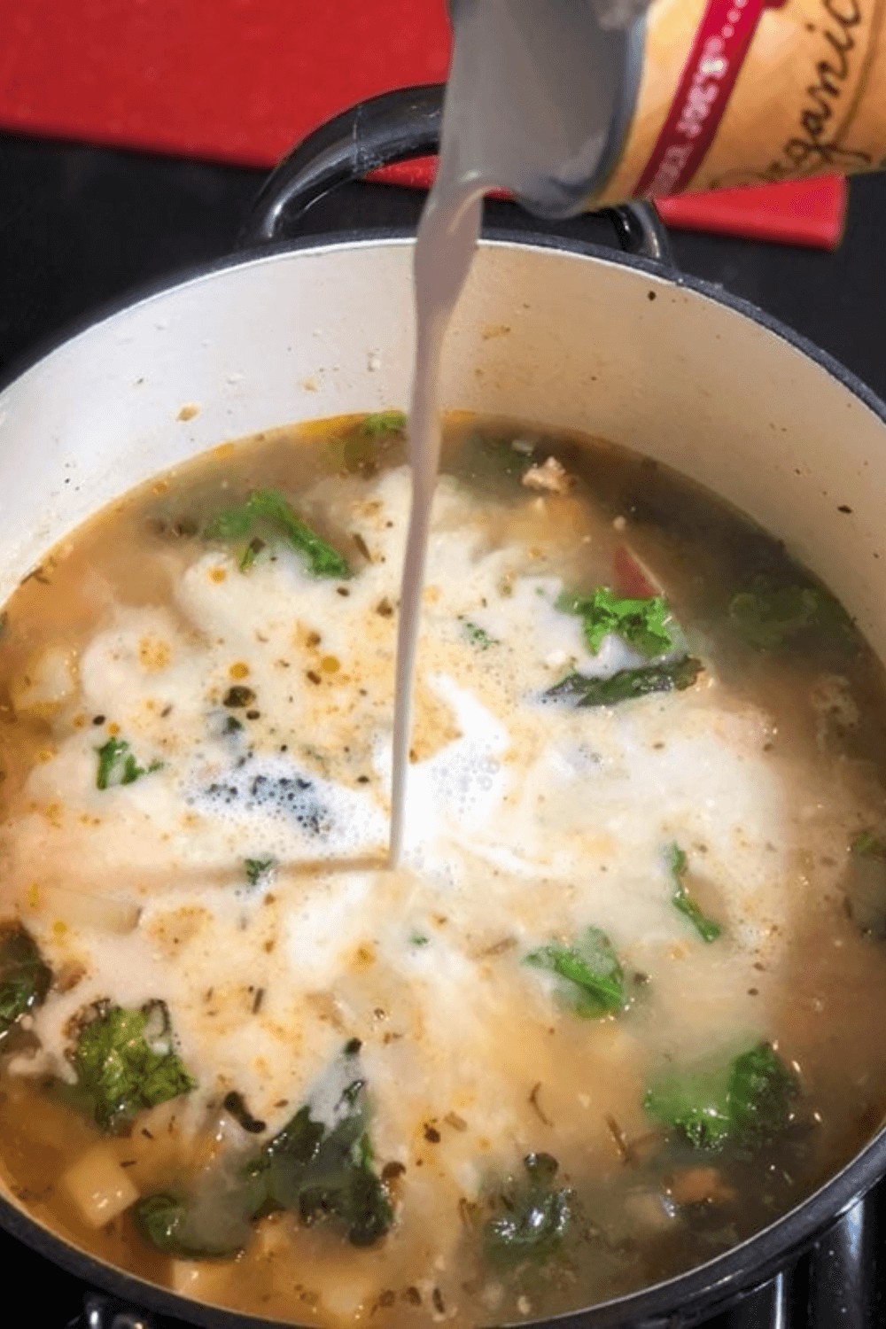 Pouring coconut milk into the Zuppa Toscana Soup