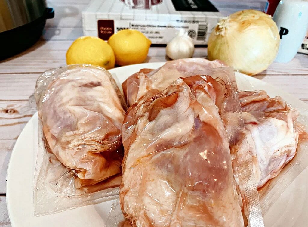  Chicken breasts uncooked on a white plate.