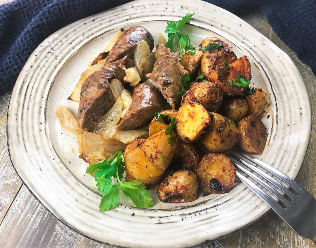 chorizo with spanish-style potatoes on a white plate with a fork