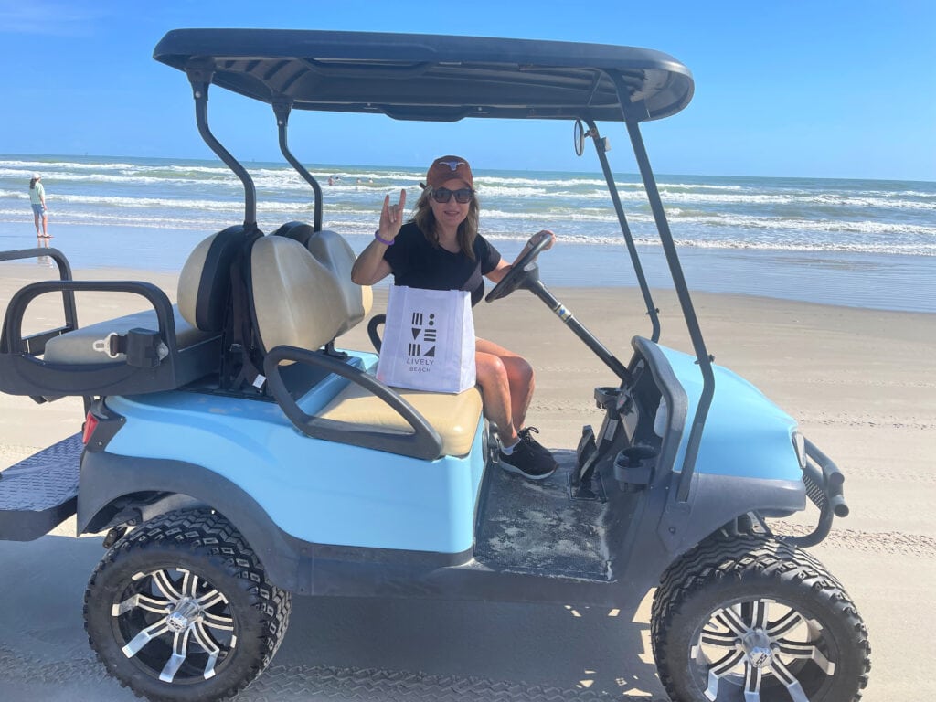 Lori Felix riding in a golf cart on Lively Beach