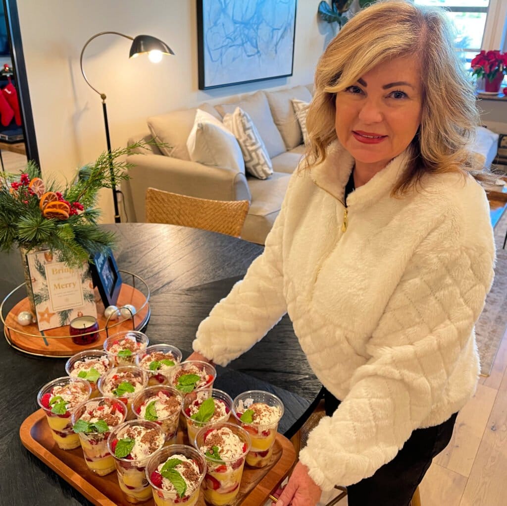 Lori Felix, serving Individual Trifle Desserts with Pound Cake, Pudding, Berries and Whipped Cream topped with a Mint Leaf