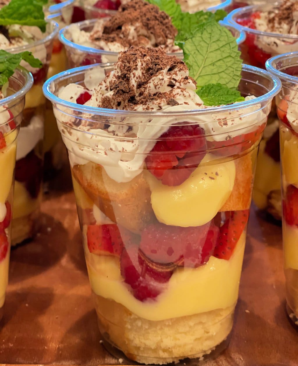 Close up of Individual Trifle Desserts with Pound Cake, Pudding, Berries and Whipped Cream topped with a Mint Leaf