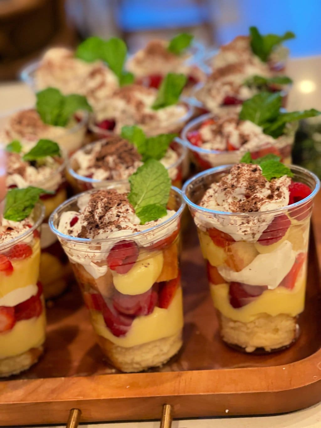 Individual Trifle Desserts with Pound Cake, Pudding, Berries and Whipped Cream topped with a Mint Leaf