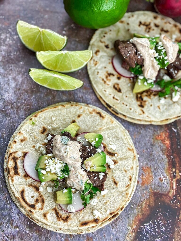 preparing Mexican Steak Street Tacos Recipe garnished with lime wedges