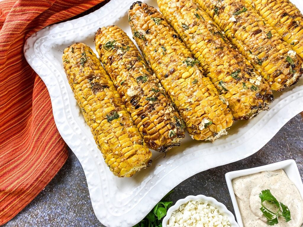 broiled mexican street corn on a white serving plate