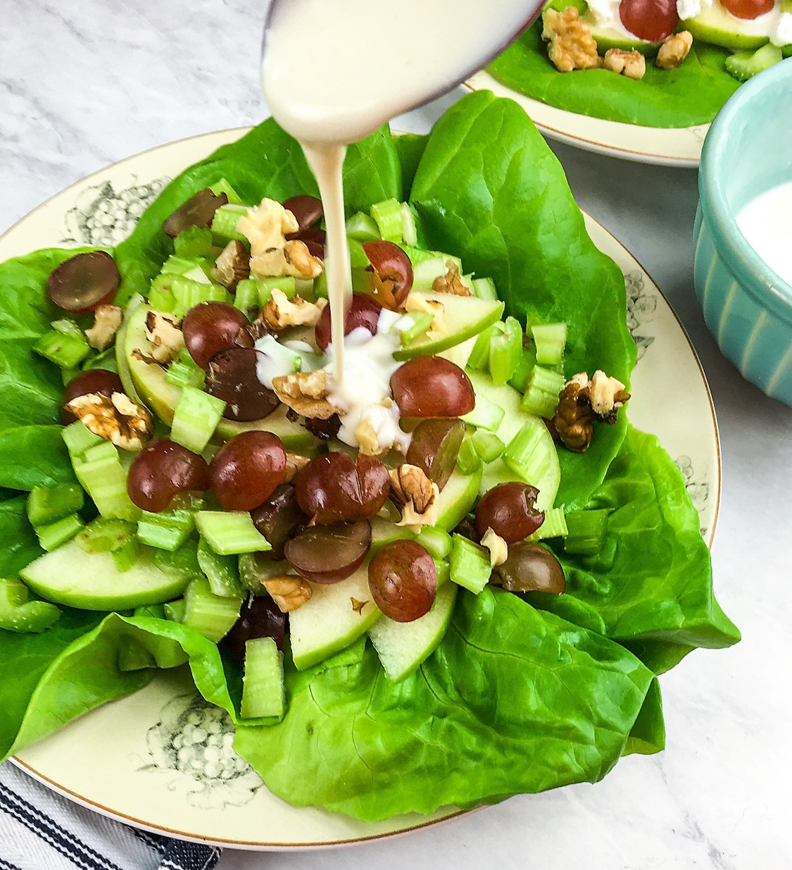 Pouring the creamy salad dressing on the Deconstructed Waldorf Salad