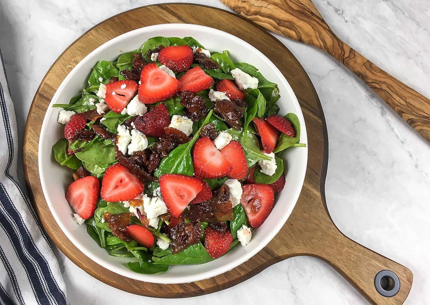 Salad with Spinach and Warm Bacon Dressing on a serving plate