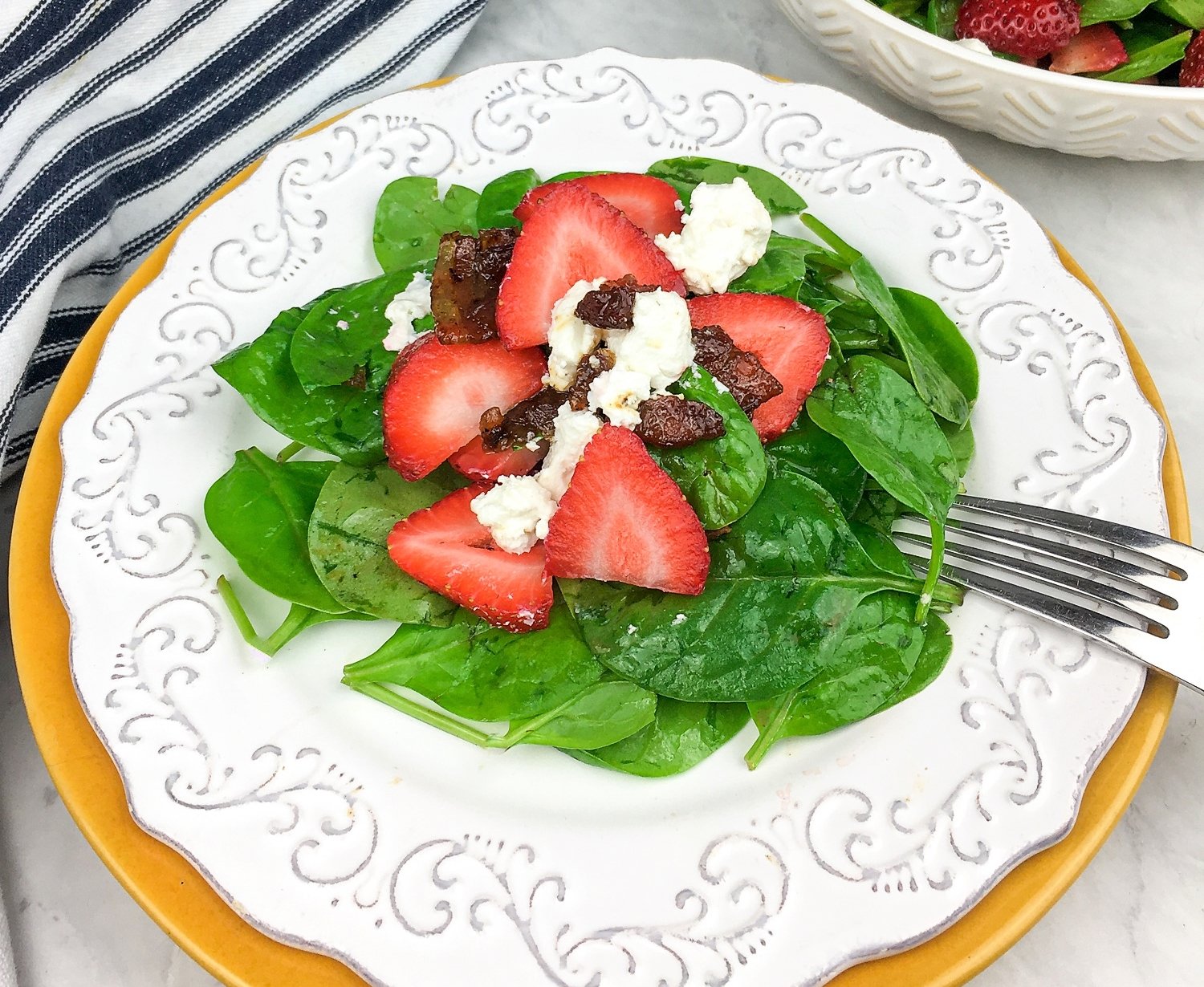 Salad with Spinach and Warm Bacon Dressing on white plate