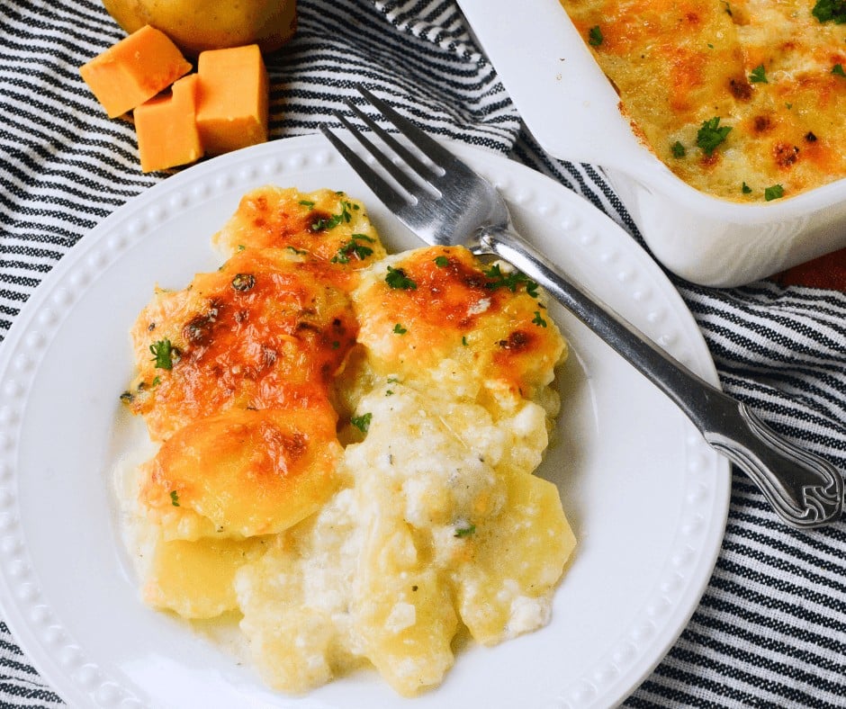 A serving of Delicious Scalloped Potatoes on a white plate