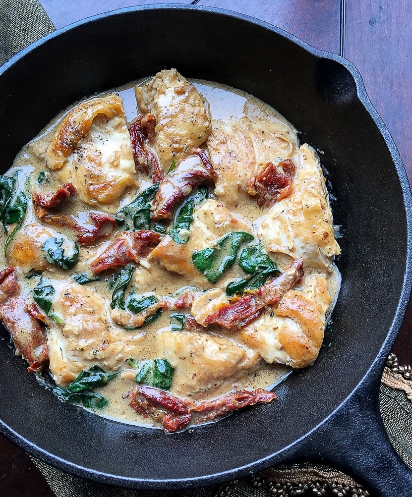 Chicken with Creamy Pecorino Sauce on a balck skillet