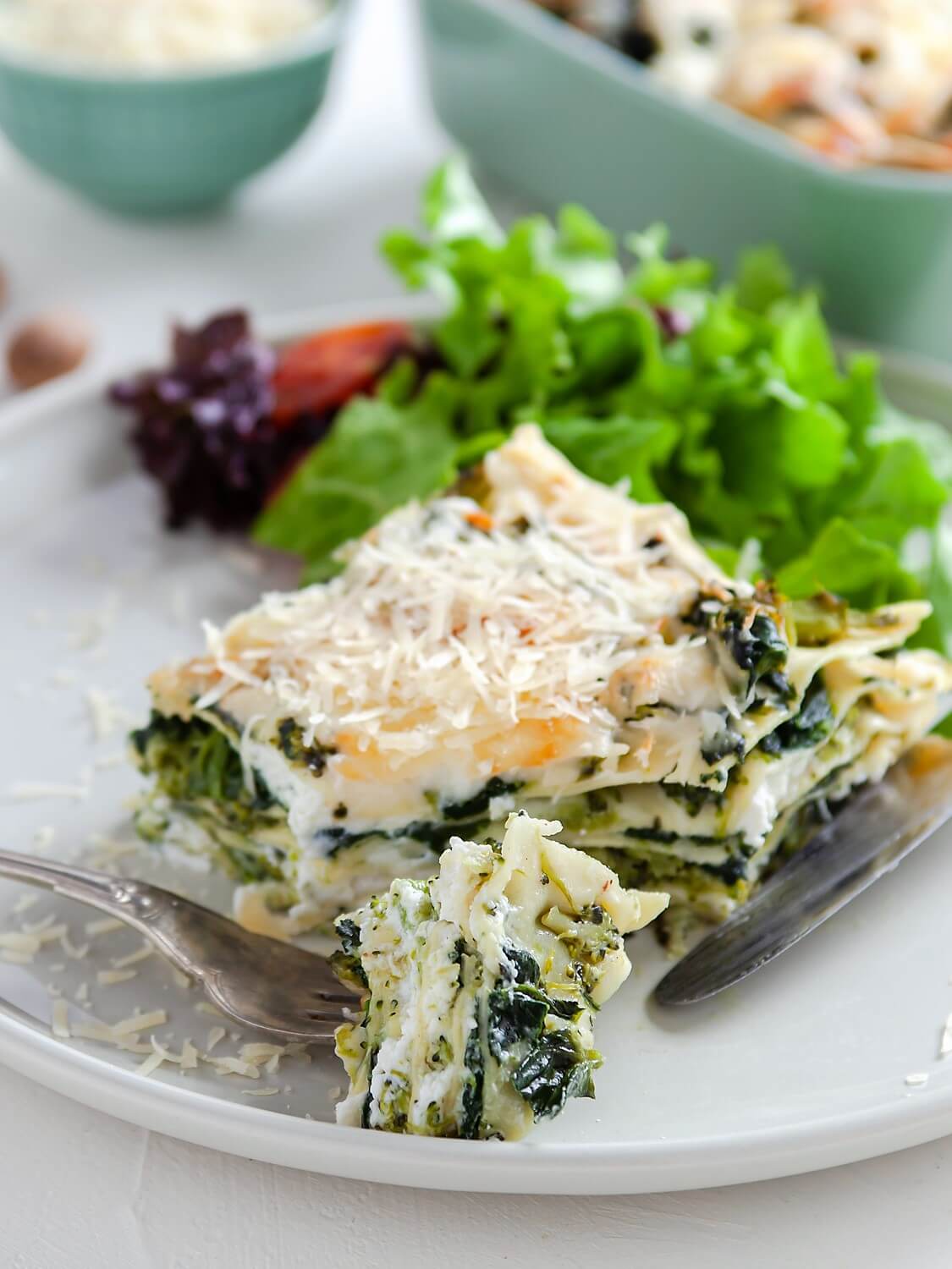 Spinach and Broccoli Lasagna with a side salad on a blue plate