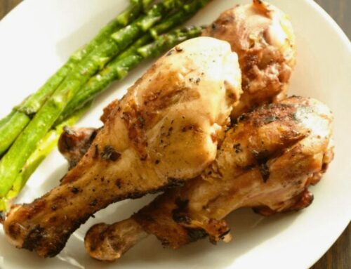 Three pieces of Cilantro Lime Grilled Chicken Drummies served with asparagus on a white plate