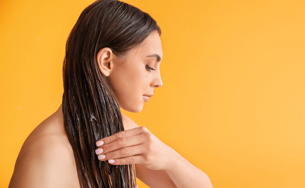 Woman applying coconut oil on her hair