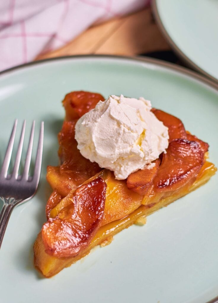 a slice of Apple Tarte Tatin with whipped cream on top