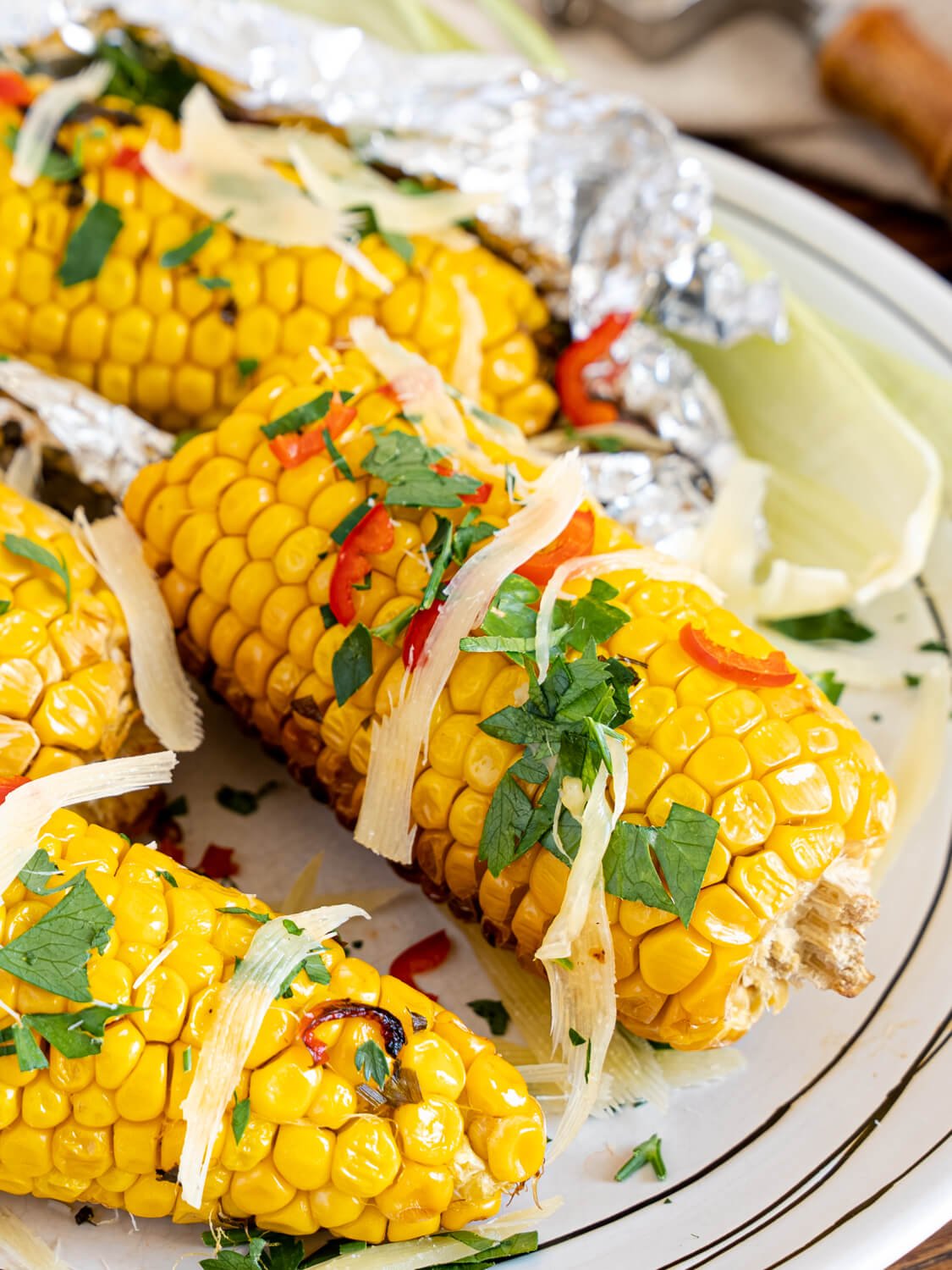 Grilled Corn On The Cob With Herb Butter on a white plate