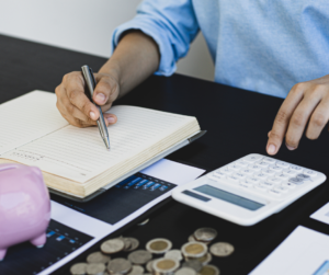 calculator, notepad, coins and piggy bank graphic about money saving tips