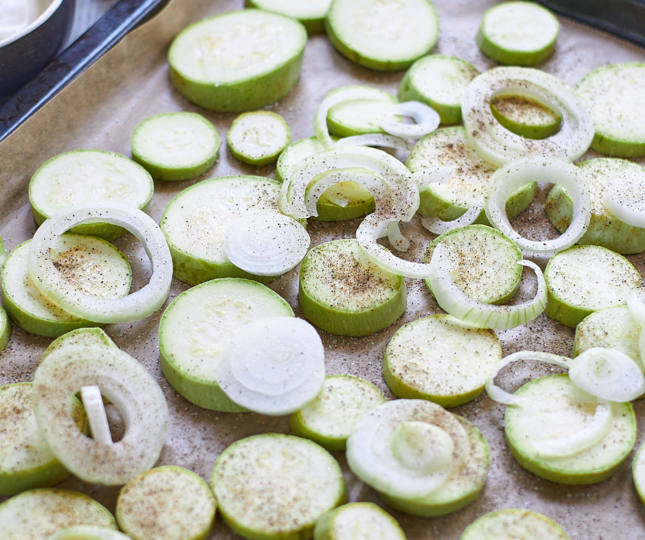 sliced zucchini and onions on a sheet pan