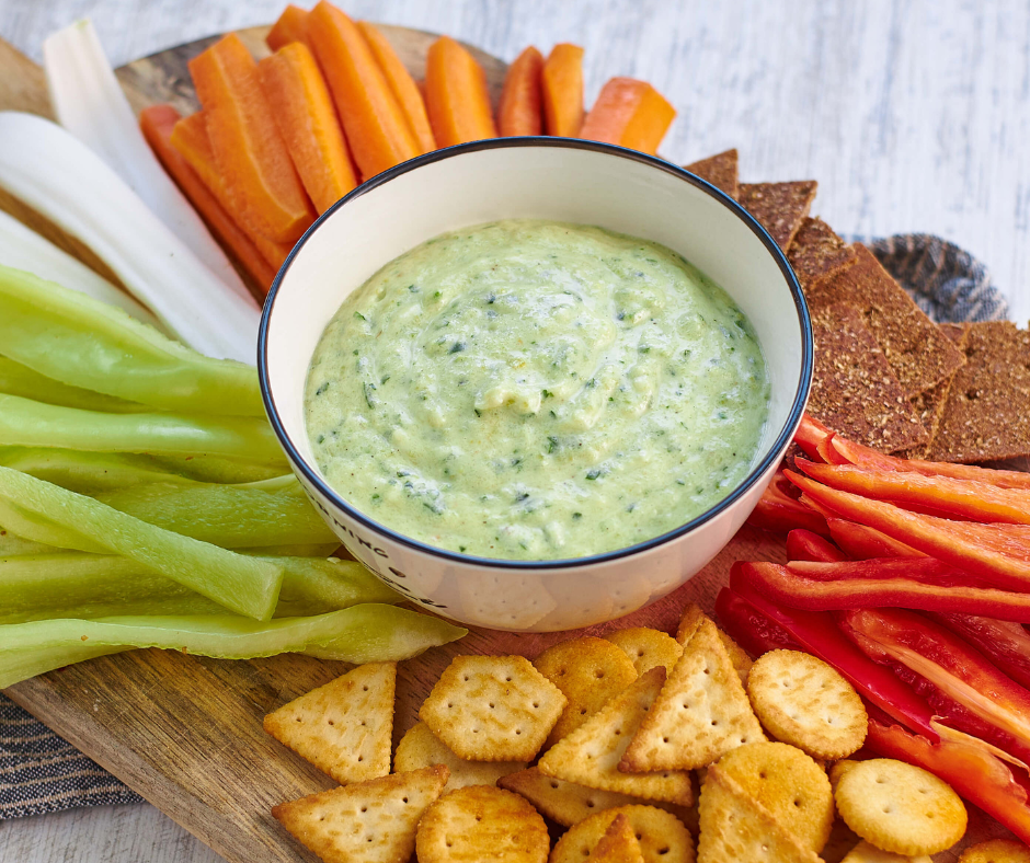 zucchini dip pictured with vegetables and crackers for dipping