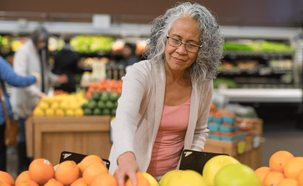 Elderly woman shopping for fruits