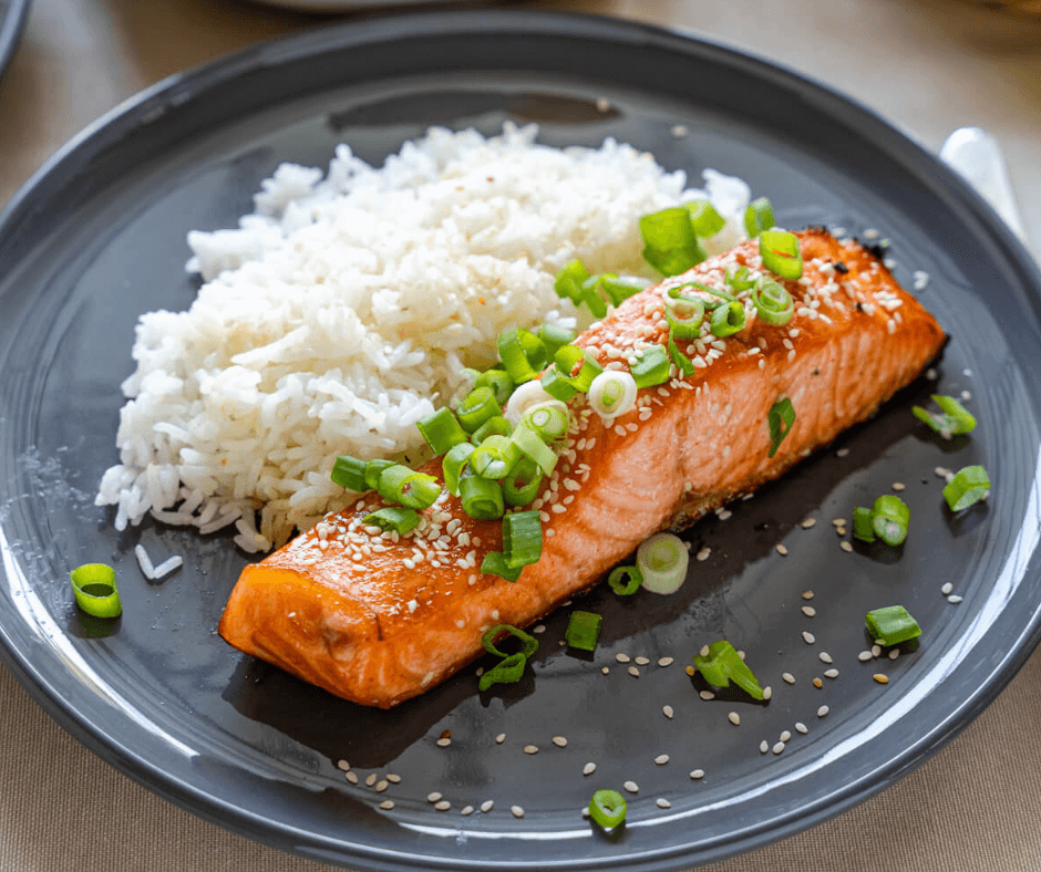 Honey Sriracha Salmon with cooked white rice on a gray plate