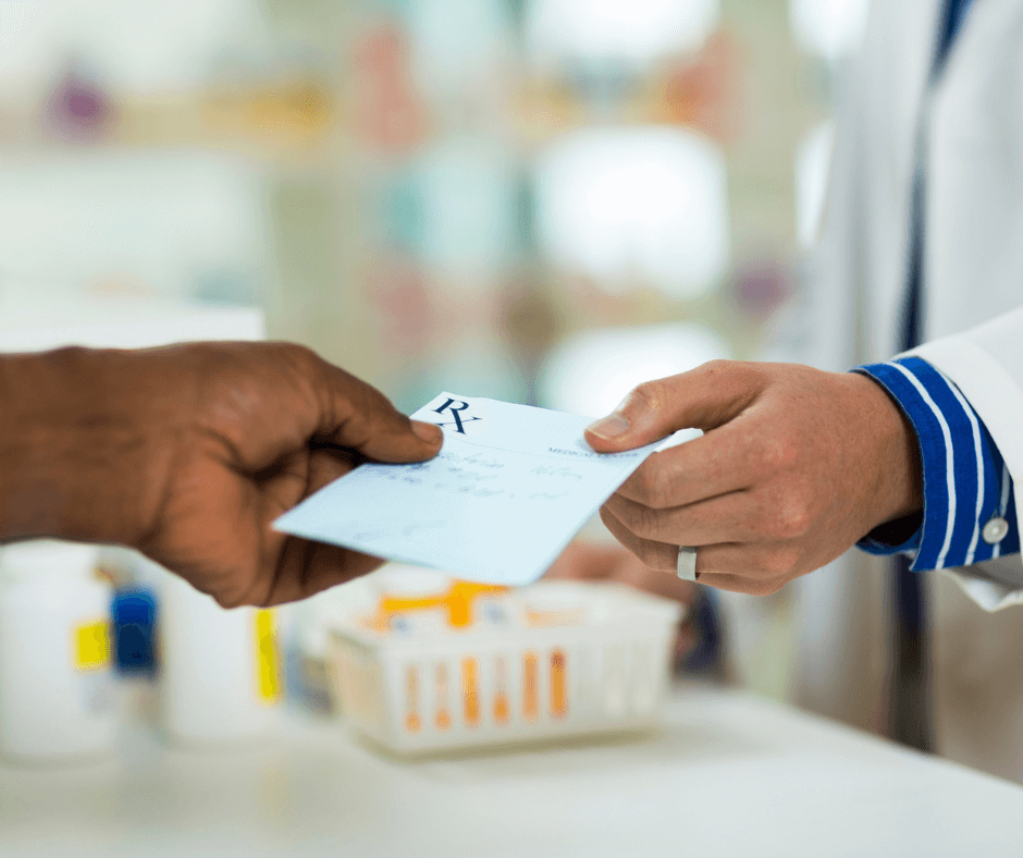 A man handing a prescription to a pharmacist