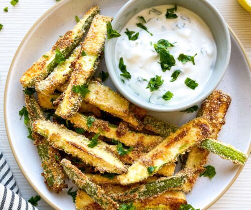 A closeup of Baked Zucchini Fries with Greek Yogurt Dip on a white plate