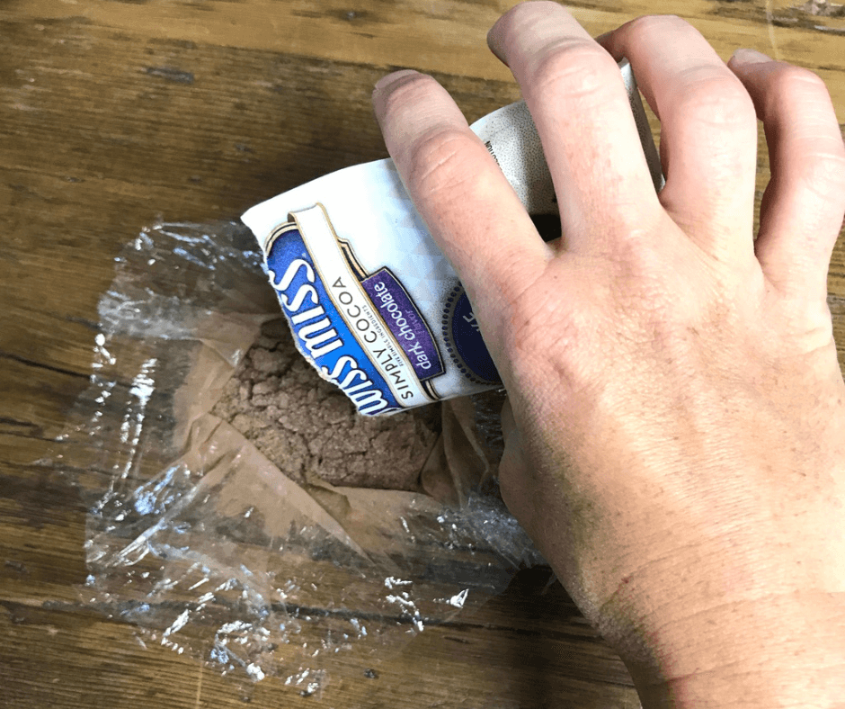 Pouring the Swiss Miss chocolate powder into the cellophane