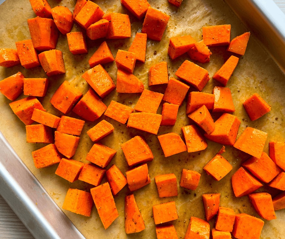 Sweet potato cubes on a rimmed baking sheet