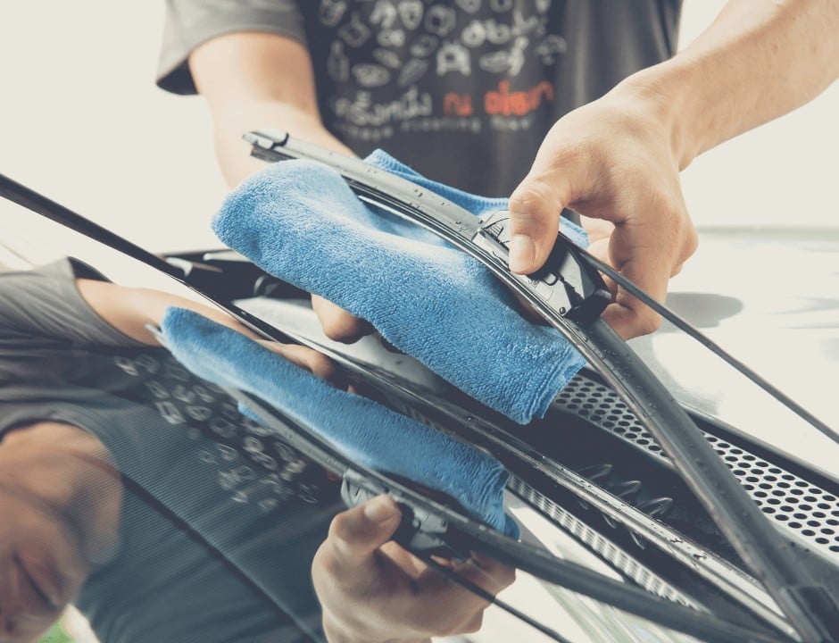 A man cleaning his windshield