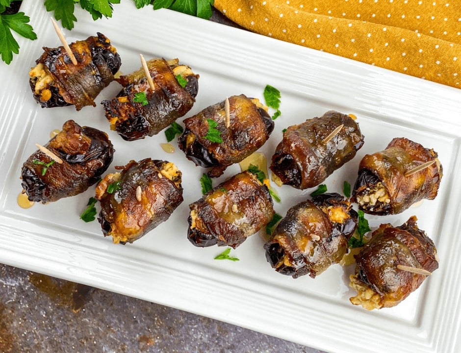 A serving plate full of Bacon-Wrapped Stuffed Dates