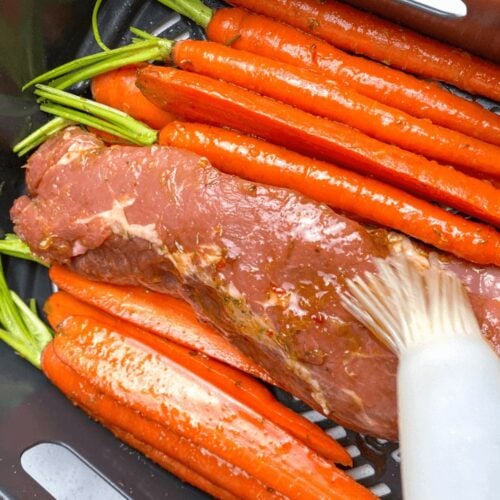 Adding the orange glaze to the carrots and pork tenderloin