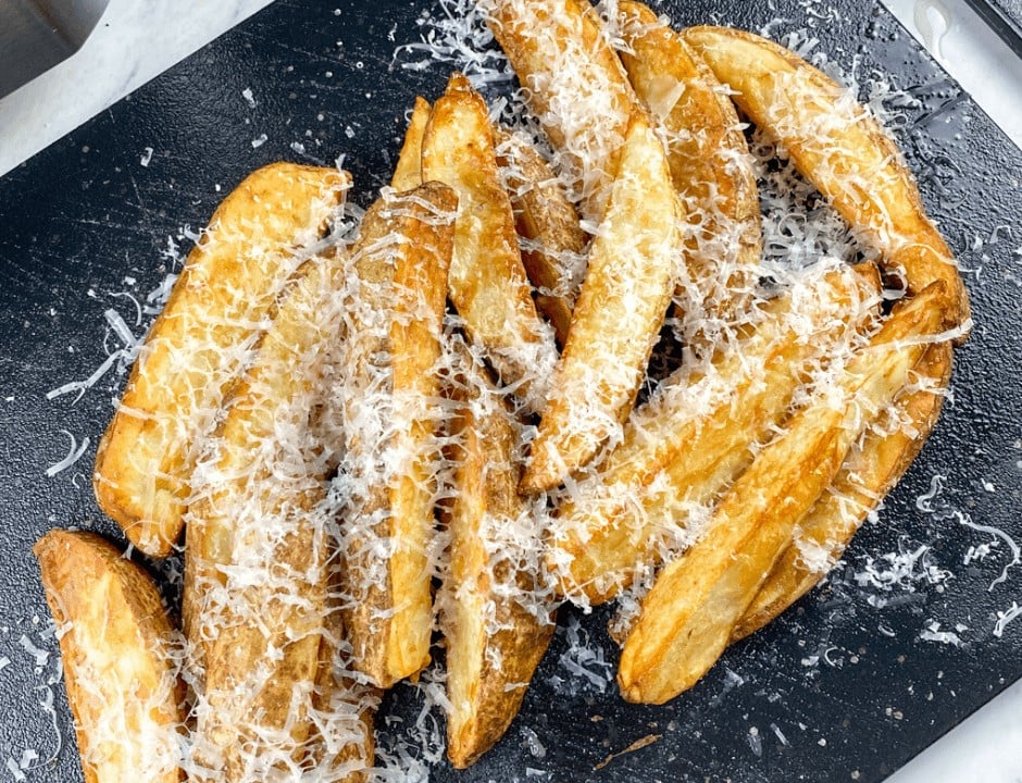 Air Fryer Truffle Potato Wedges with Parmesan on a black serving board