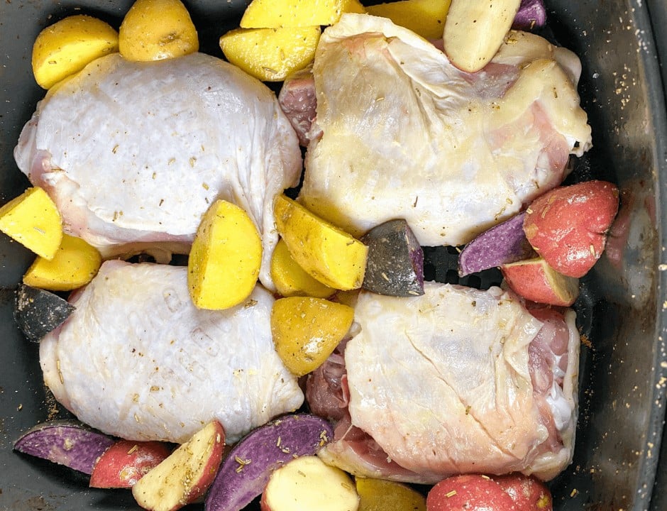 Cooking the chicken thighs and roasting the potatoes inside the air fryer