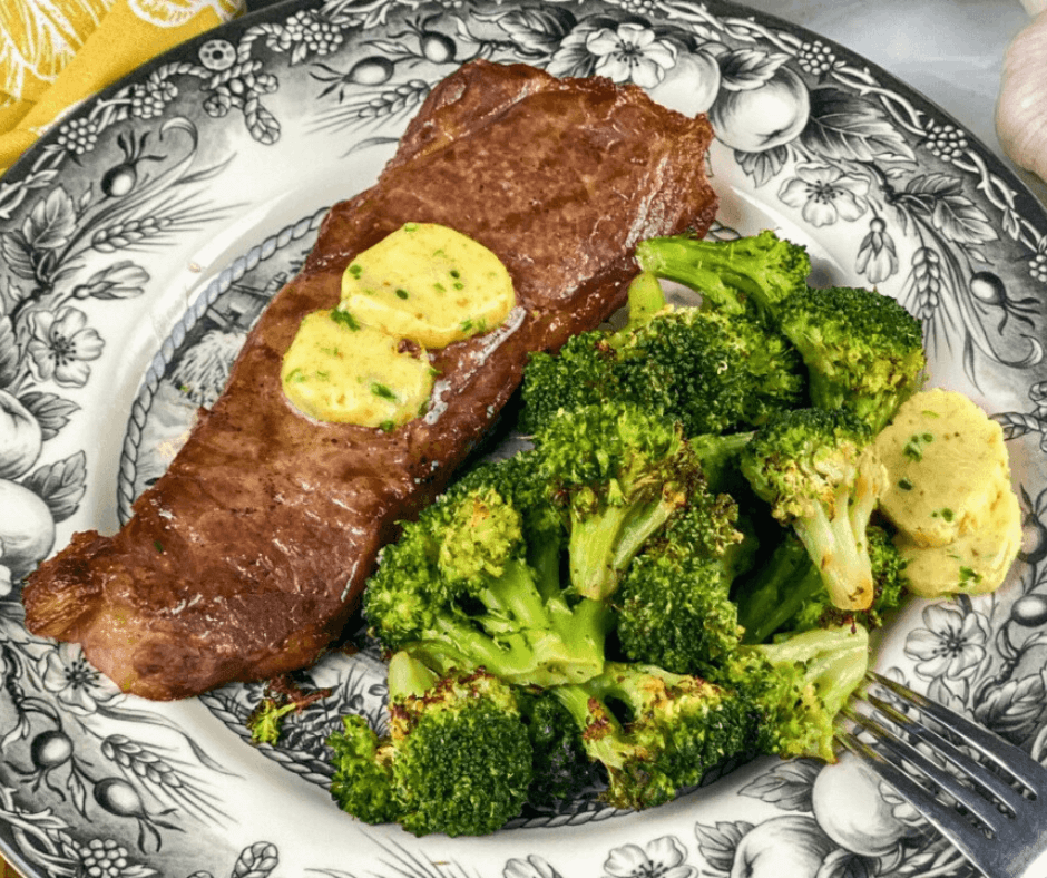 Perfect Air Fryer Steak with Garlic Butter beside broccoli served on a plate