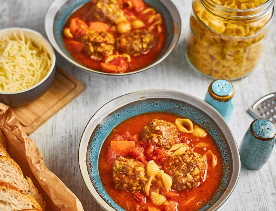 Two bowls of Homemade Italian Meatball Soup with no parsley and parmesan cheese topping